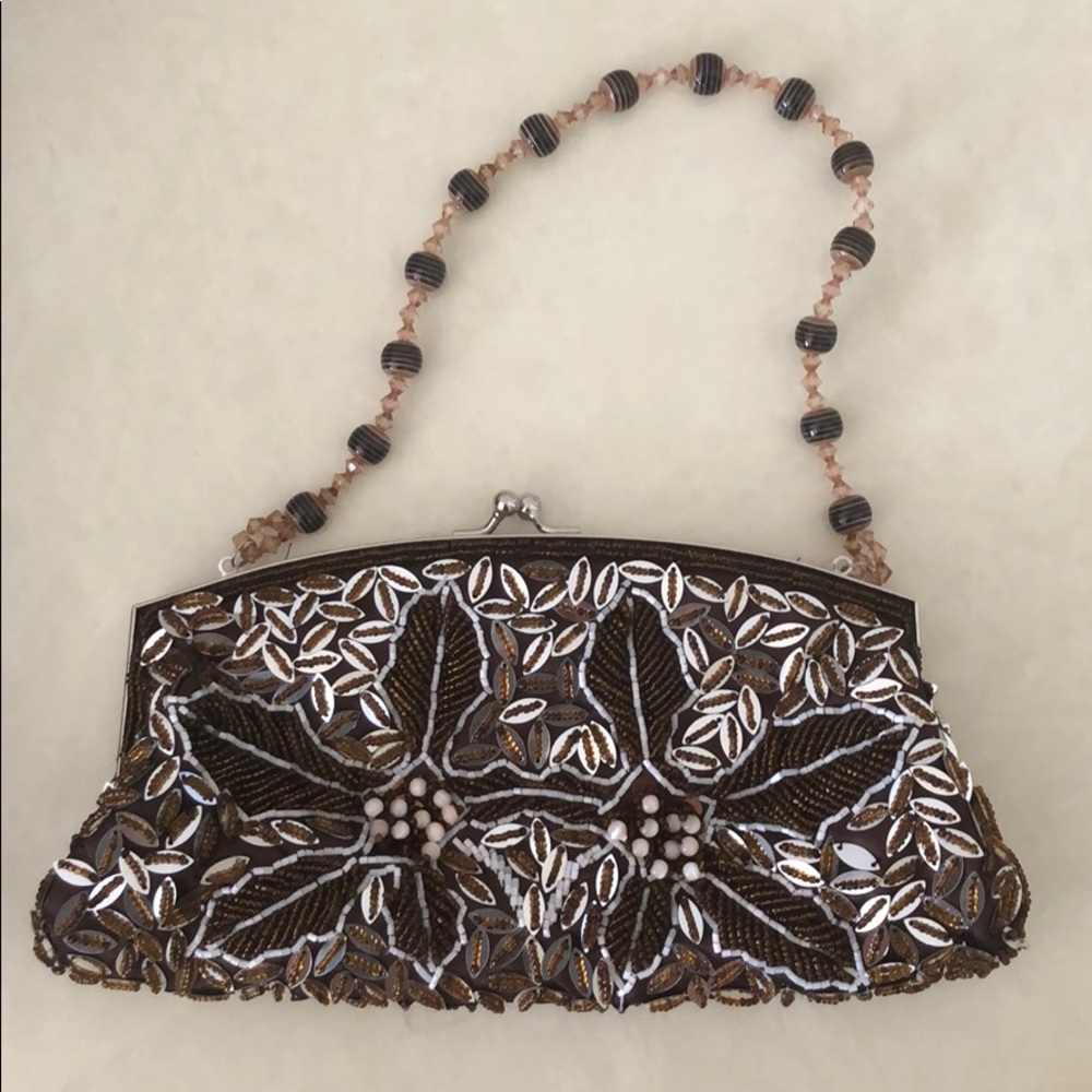Woman’s beaded clutch in brown and gold color.
